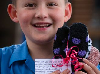 Suncoast Primary student wrapping winter woolly gifts for the homeless